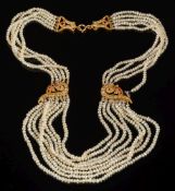 A seed-pearl multi-string necklace: with gem-set fittings and bolt ring clasp stamped '750'.