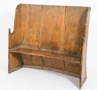 A 19th Century pine curbed wing back settle:, with shaped arm supports and solid seat,