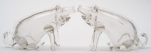 A pair of clear glass novelty decanters in the form of pigs: each in seated posture with raised