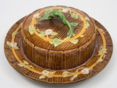 A George Jones majolica butter dish and cover: of circular form with rustic handle,