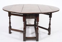 An 18th century oak oval gateleg table:, with a hinged top,