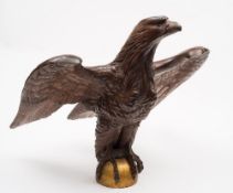 A large carved eagle lectern: with partially outstretched wings, perched on a gold painted orb,