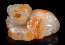 A Chinese agate carving of a Buddhist lion and young: both reclining,