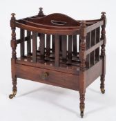 An early 19th Century mahogany four division canterbury:, with shaped central carrying handle,