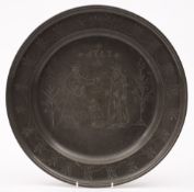An 18th century Continental pewter charger: the centre decorated with a seated lion flanked by a