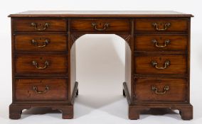 A George III mahogany kneehole desk:, the rectangular top inset with a panel of tooled leather,