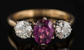 A pink sapphire and diamond three-stone ring: with central oval pink sapphire 7.7mm x 6.