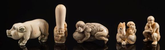 A Japanese carved ivory miniature netsuke of a crouching man: smoking a pipe whilst his phallus