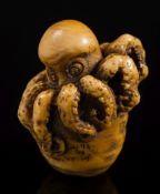 A Japanese carved ivory netsuke of an octopus emerging from a shell: signed Tomoyuki, Meiji period,