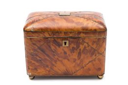 An early 19th century blonde tortoiseshell tea caddy: the shallow domed hinged top enclosing two