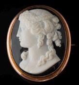 A layered agate cameo oval brooch: the black and white cameo depicting a young woman looking to