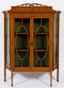 An Edwardian satinwood, inlaid and decorated display cabinet:, of canted outline,