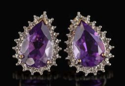 A pair of amethyst and diamond pear shaped ear studs: each with a central pear-shaped amethyst