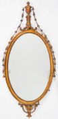 An early 19th century carved giltwood oval mirror: in the neo-classical taste,