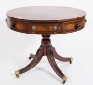 A Regency mahogany, crossbanded and inlaid circular revolving drum top library table:,