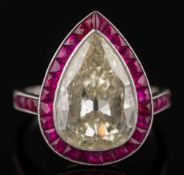 A pear-shaped diamond and ruby cluster ring: with a central pear-shaped diamond approximately 14.