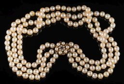 A cultured pearl three-strand necklace: the cultured pearls approximately 7mm diameter and on 9ct