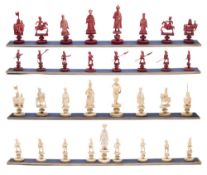 A matched carved ivory chess set: one side stained red, the other left natural,