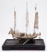 A Chinese white metal model of a three-masted war junk: fitted with cannon and oars, 24cm.