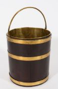 An 18th century mahogany brass bound cylindrical bucket: with brass swing handle and liner,