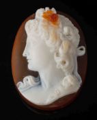 A three-layer agate oval cameo: depicting a young woman in profile looking to dexter,