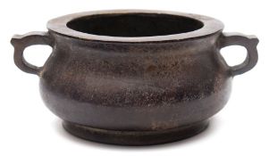 A Chinese bronze censer: of squat circular form, with loop carrying handles to the sides,