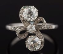 A platinum and diamond ribbon cross-over cluster ring: the two principal round old brilliant-cut
