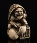 A Japanese carved ivory okimono: depicting an oni with a turtleshell on it's back and squatting on