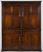 An early 19th Century oak housekeeper's cupboard:, the upper part with a moulded cornice,