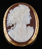 An oval hard-stone cameo portrait brooch: the oval cornelian and white agate layered cameo carved