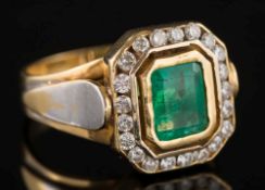 An emerald and diamond rectangular cluster ring: the emerald approximately 8mm long x 6mm wide,