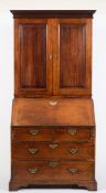 A George III mahogany bureau cabinet:, the upper part with a moulded cornice,