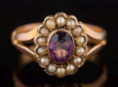 A 9ct gold, amethyst and seed pearl oval cluster ring: the oval amethyst 6.2mm long x 4.