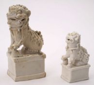 Two Chinese Dehua incense stick holders: each in the form of a seated lion dog with one paw resting