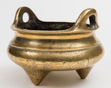 A Chinese polished bronze tripod censer: of squat circular form, with loop handles to the rim,