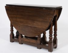 An oak oval gateleg table:, with a hinged top on turned legs, united by plain stretchers,