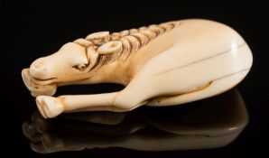 A Japanese carved ivory netsuke of a grazing horse: unsigned, Edo period, 6cm.
