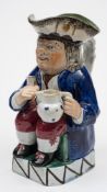An early 19th century pearl glazed pottery Toby jug: of traditional form,