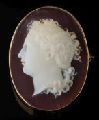 An agate oval cameo brooch: the cornelian and white cameo depicting a young woman looking to dexter,