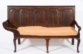 An 18th Century oak porter's settle:, the rectangular back with five fielded panels,