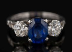 A sapphire diamond three-stone ring: with central oval sapphire 8.7mm long x 6.4mm wide x 4.