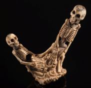 A Japanese carved antler okimono of two kneeling skeletons: unsigned, 10.5cm. high.