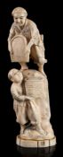 A Japanese carved ivory okimono of wheat threshers: one standing above another on a rock,