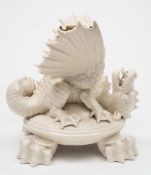 A Belleek porcelain dragon kettle stand: modelled as a dragon with wings outstretched and head