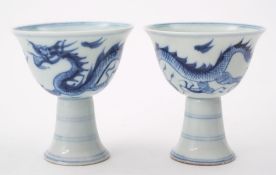 A pair of Chinese porcelain stem cups: painted in blue with a dragon,