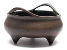A Chinese bronze tripod censer: of squat circular form,with loop carrying handles,