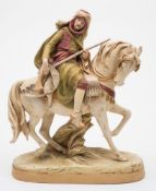 A Royal Dux Bohemia porcelain equestrian group: of a mounted Arab hunter holding a rifle with
