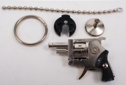 An Austrian 'Xythos-Automatic' miniature pinfire revolver:, in circular plastic case.