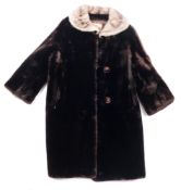 A mid-20th century lady's black cut and dyed sheepskin overcoat by the Hudson Bay Company,