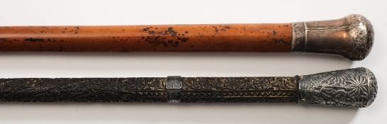 A 19th century Indian silver mounted carved ebony walking cane and one other white metal mounted